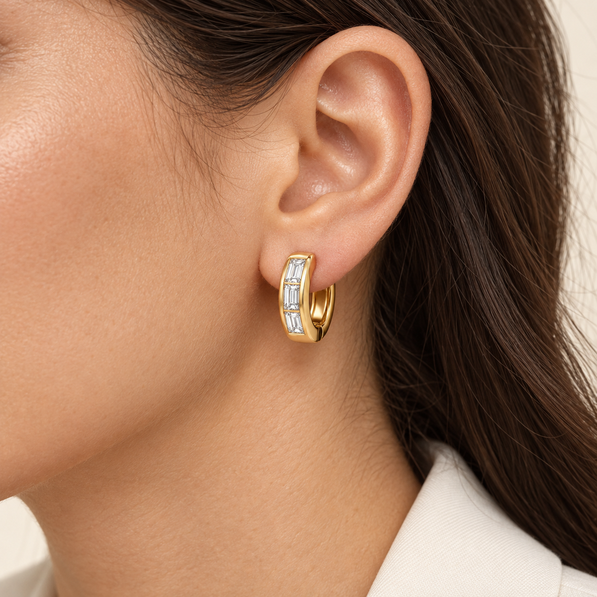MISSISSI Facet 14K yellow gold huggie with three baguette lab-grown diamonds, shown on an adult model; AI-generated wearing visualization