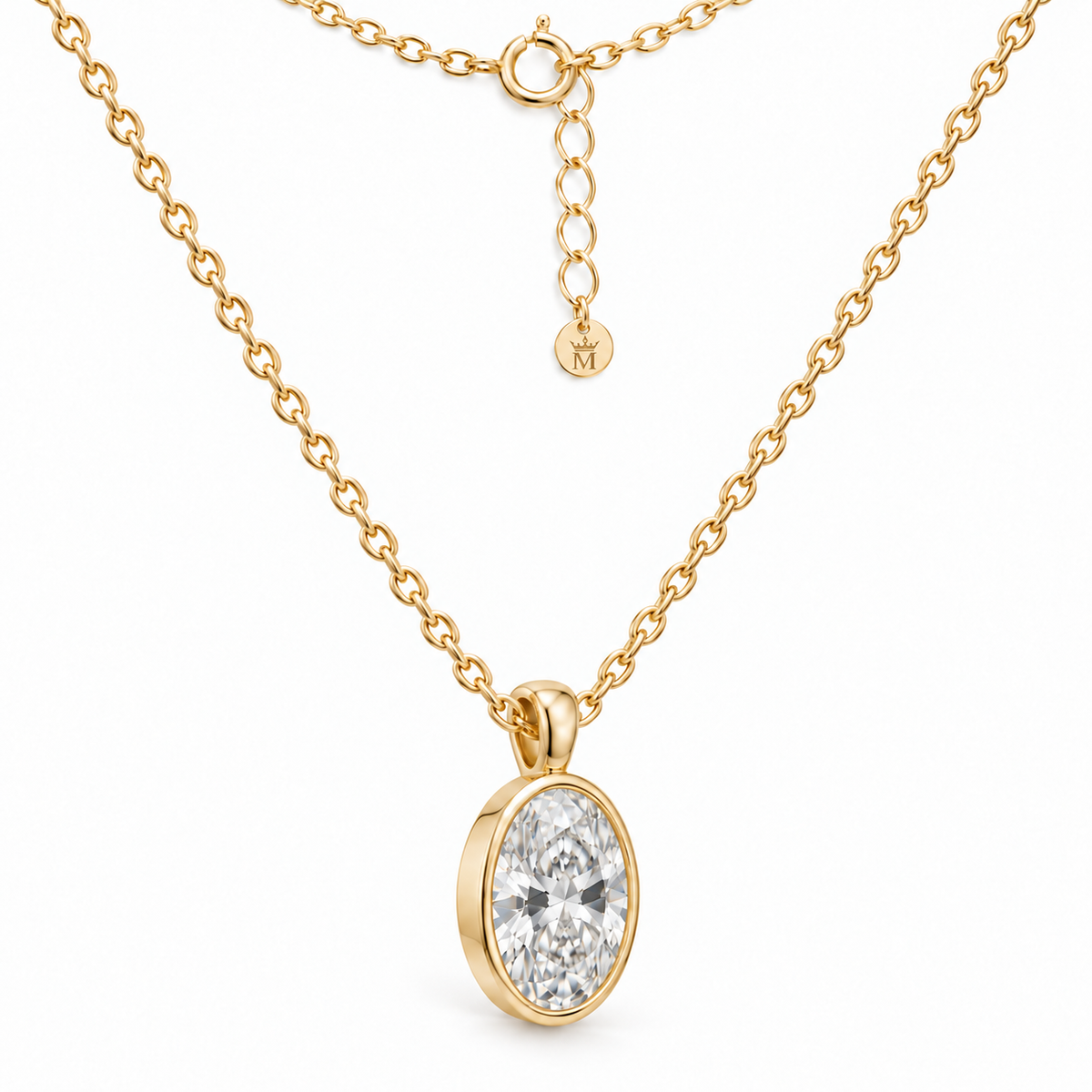 Three-quarter view of the oval lab-grown diamond bezel pendant and 14K gold chain. AI-edited crown-M engraving concept on the existing extender end disc; engraving and scale are illustrative.