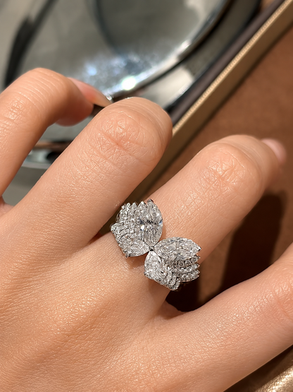A sculptural butterfly diamond ring featuring two 3-carat marquise-cut diamonds and two 2-carat pear-cut diamonds, creating 10 carats across the four featured stones. The four diamonds form luminous butterfly wings above a wide, multi-row pavé-set band.