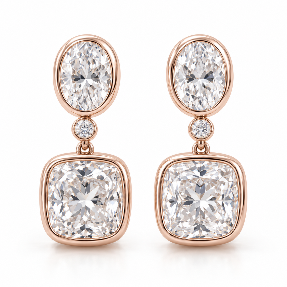 MISSISSI AA14 paired earrings in pale rose gold tone, front view showing an oval diamond above one small round connector diamond and a cushion-shaped drop in rounded bezels; design visualization