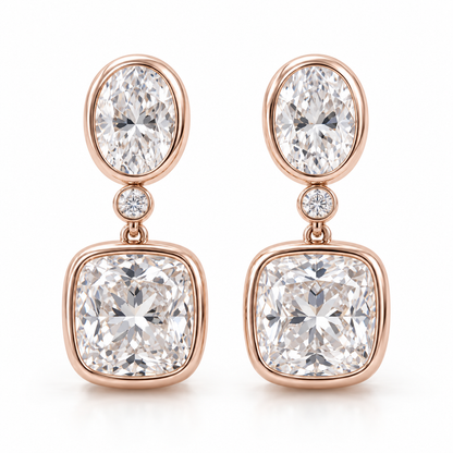 MISSISSI AA14 paired earrings in pale rose gold tone, front view showing an oval diamond above one small round connector diamond and a cushion-shaped drop in rounded bezels; design visualization