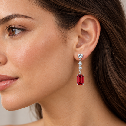 Adult model wearing one RE02 emerald-cut ruby and three-diamond drop earring; design visualization