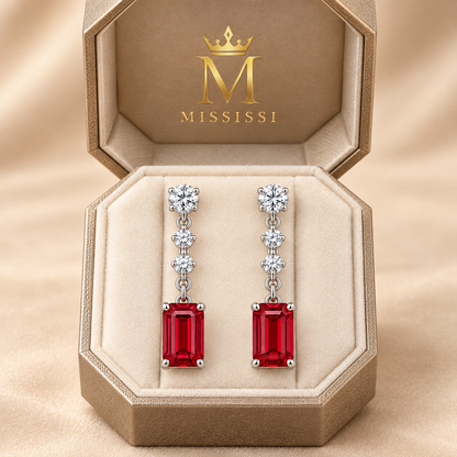 RE02 emerald-cut ruby drop earring pair in champagne octagonal MISSISSI packaging; design visualization