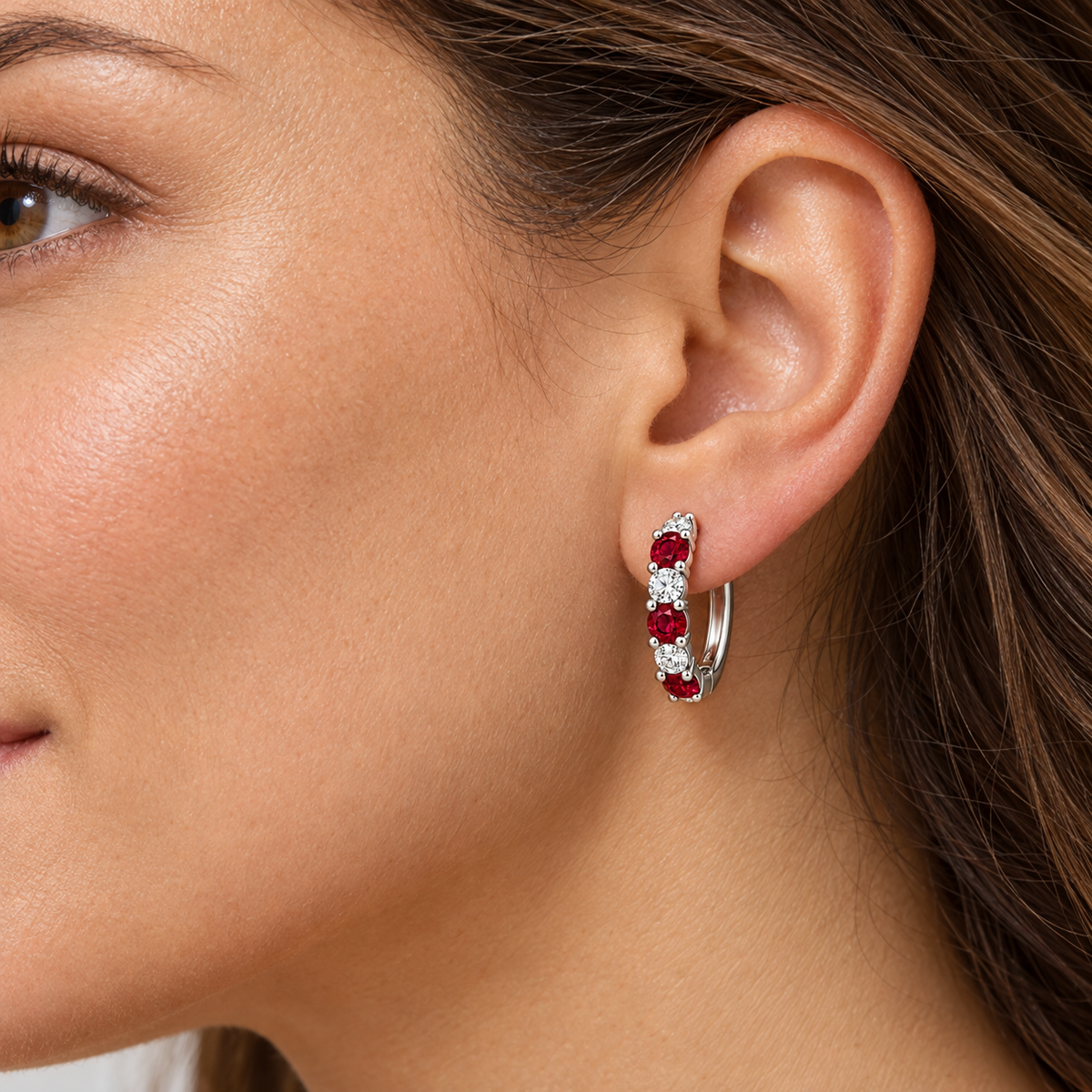 Adult model wearing one RE04 white gold ruby and diamond hoop earring; design visualization