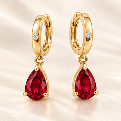 Three-quarter view of RE05 yellow gold huggies with permanently linked pear-shaped ruby drops; design visualization