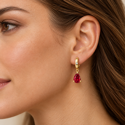 Adult model wearing one RE05 yellow gold huggie with pear-shaped ruby drop; design visualization