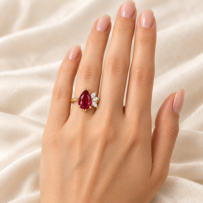 MISSISSI Crimson Feather pear-shaped lab-grown ruby ring in yellow gold with three marquise lab-grown diamond accents, left-hand wearing visualization.