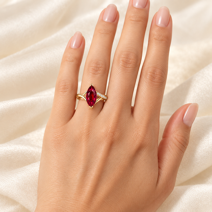MISSISSI Crimson Crossing marquise lab-grown ruby ring in yellow gold with round lab-grown diamond accents on one crossing shoulder, left-hand wearing visualization.