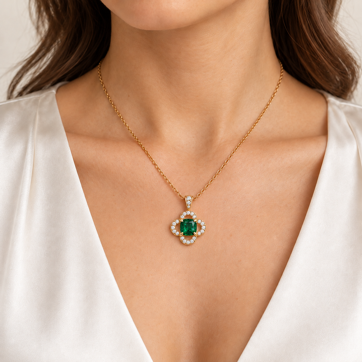 MISSISSI CLOISTER cushion lab-grown emerald quatrefoil necklace in yellow gold, shown on an adult model with light warm skin; AI-generated wearing design visualization.