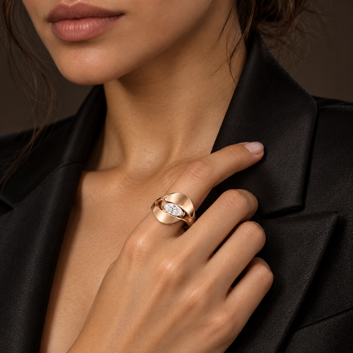 Eclipse pale rose-gold marquise diamond ring shown on a hand resting on a black jacket lapel, design visualization.