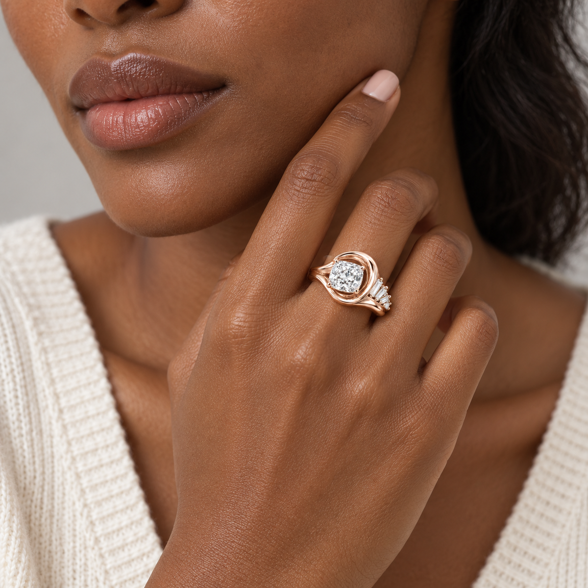 Tidal pale rose-gold ring shown on a hand near the jawline with an ivory knit top, design visualization.