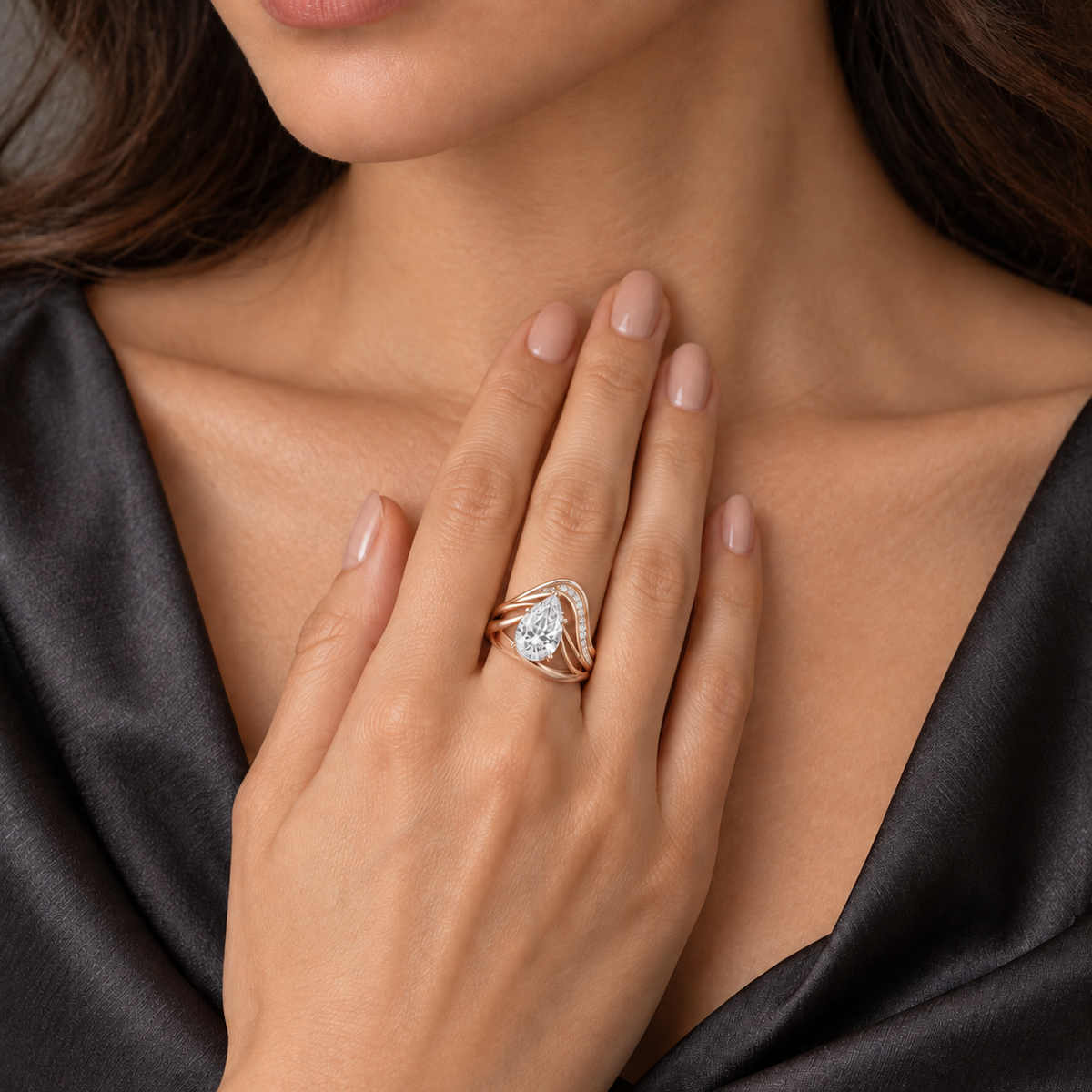 MISSISSI Aerial pale rose gold pear lab-grown diamond arc ring worn snugly with pear aligned toward fingertip against charcoal silk; design visualization