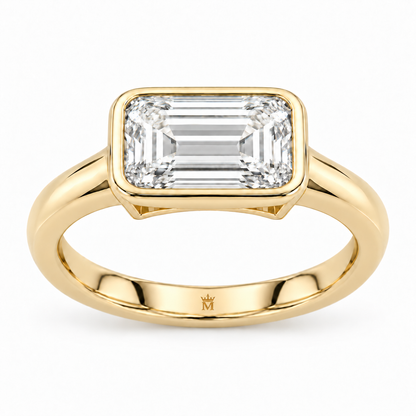 MISSISSI horizon east west ring front view. AI-edited crown-M engraving concept inside the lower band; engraving and scale are illustrative.