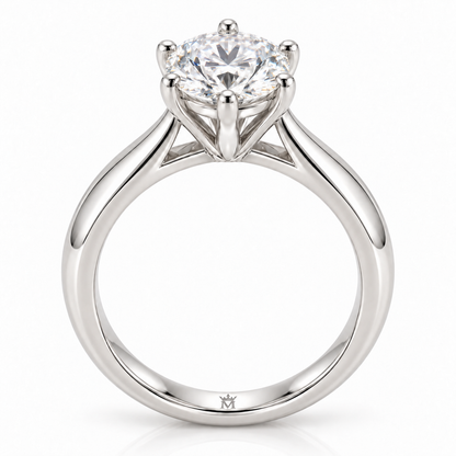 AI-generated design concept of a round brilliant ring, front. Illustrative geometry and scale; not a manufactured product photograph. Crown-M engraving design is shown inside the lower band; engraving is illustrative.
