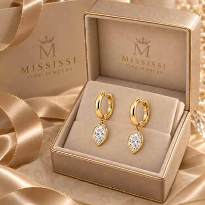 Aurelle jewelry presented in champagne beige MISSISSI Fine Jewelry gift packaging. AI-edited crown-M engraving concept on visible inner rear hoop surfaces; engraving and scale are illustrative.
