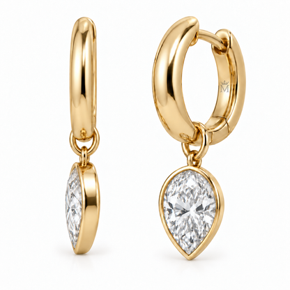 MISSISSI aurelle pear drop huggies profile view. AI-edited crown-M engraving concept on visible inner rear hoop surfaces; engraving and scale are illustrative.