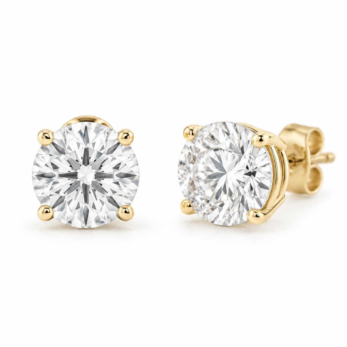 Matched pair of round diamond stud earrings in four-prong yellow gold settings.