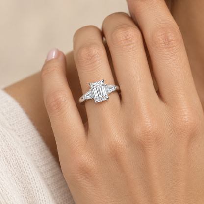 AI-generated design concept of an emerald cut ring, on hand. Illustrative geometry and scale; not a manufactured product photograph.