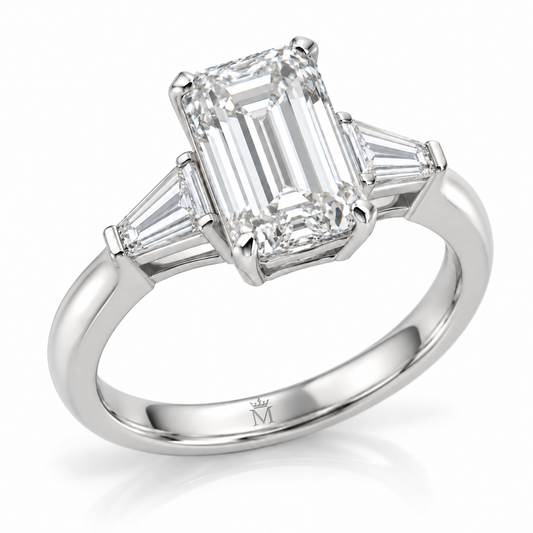 AI-generated design concept: Emerald cut ring, Prong-set center with two tapered baguette side stones, three-quarter view. Metal appearance is illustrative. Crown-M engraving design is shown inside the lower band; engraving is illustrative.