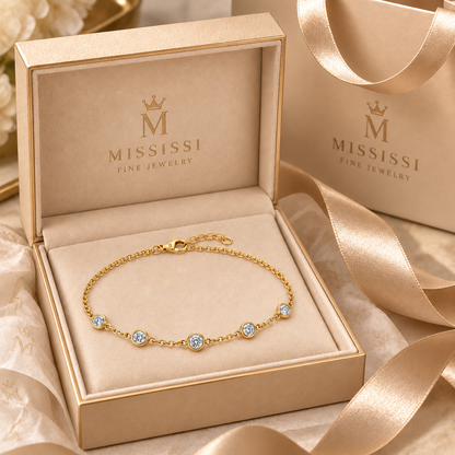 Constellation jewelry presented in champagne beige MISSISSI Fine Jewelry gift packaging. AI-edited crown-M engraving concept on the existing lobster clasp shell; engraving and scale are illustrative.