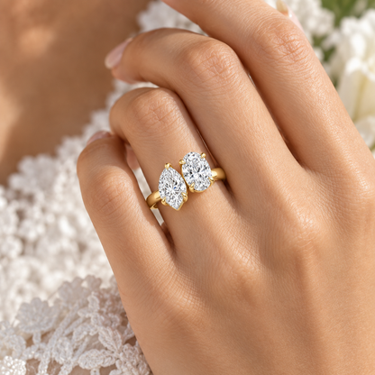 Amour pear and oval Toi et Moi engagement ring in 14K yellow gold, worn by a model.