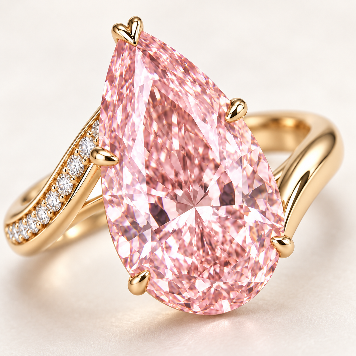 AI design preview close-up of Blush Current pink pear diamond, protective V-tip and asymmetrical yellow-metal ribbons