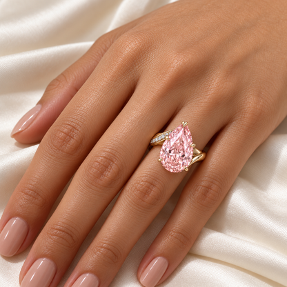 AI design preview of Blush Current pink pear ring on an adult hand; scale illustrative