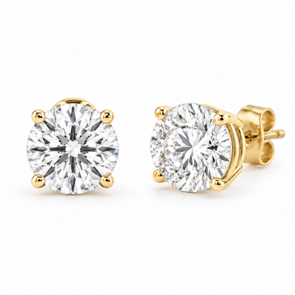 Matched pair of round lab-grown diamond stud earrings in four-prong gold settings on white.
