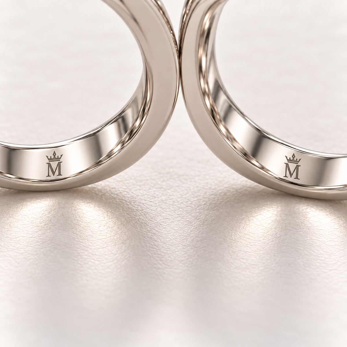 AI design preview close-up of matching crowned-M engravings inside the lower shanks of both CONFLUENCE rings