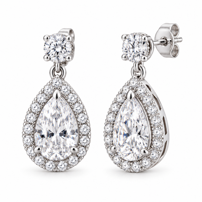 Cora pear halo drop earrings in 14K white gold, on a clean white background, front hero view.