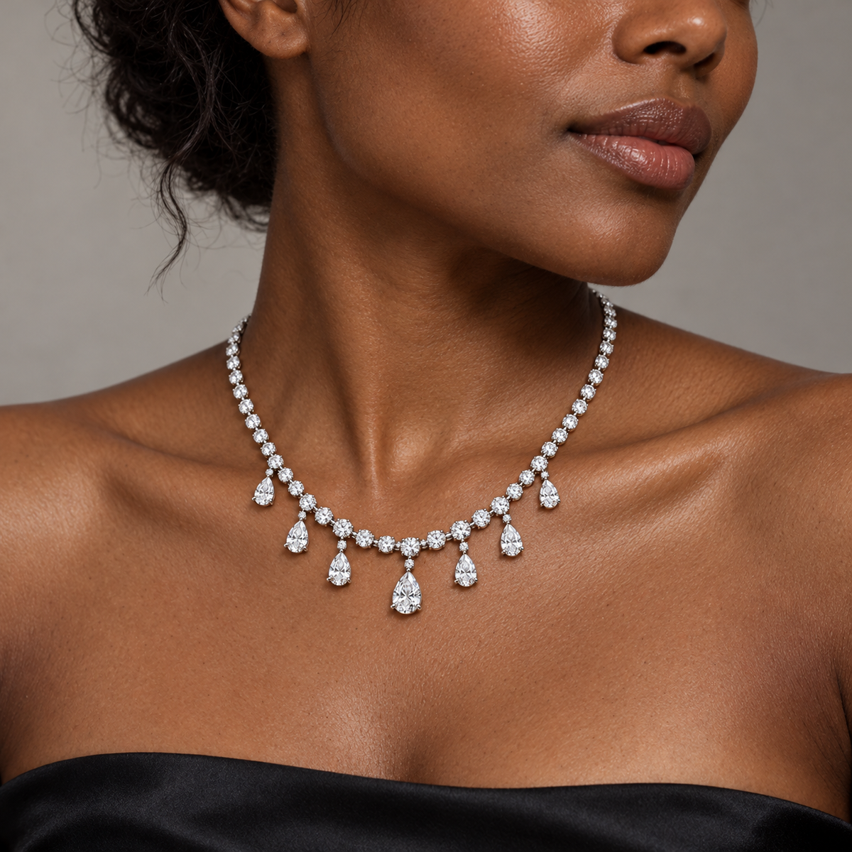 Adult model with deep skin wearing the Dew Garland seven-pear-drop necklace