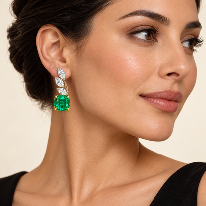 MISSISSI Verdant Frond GE26-E04 on an adult model; AI-generated illustrative styling visualization, not a customer photograph or exact scale reference. Three marquise white diamond leaves and a cushion-cut green emerald.