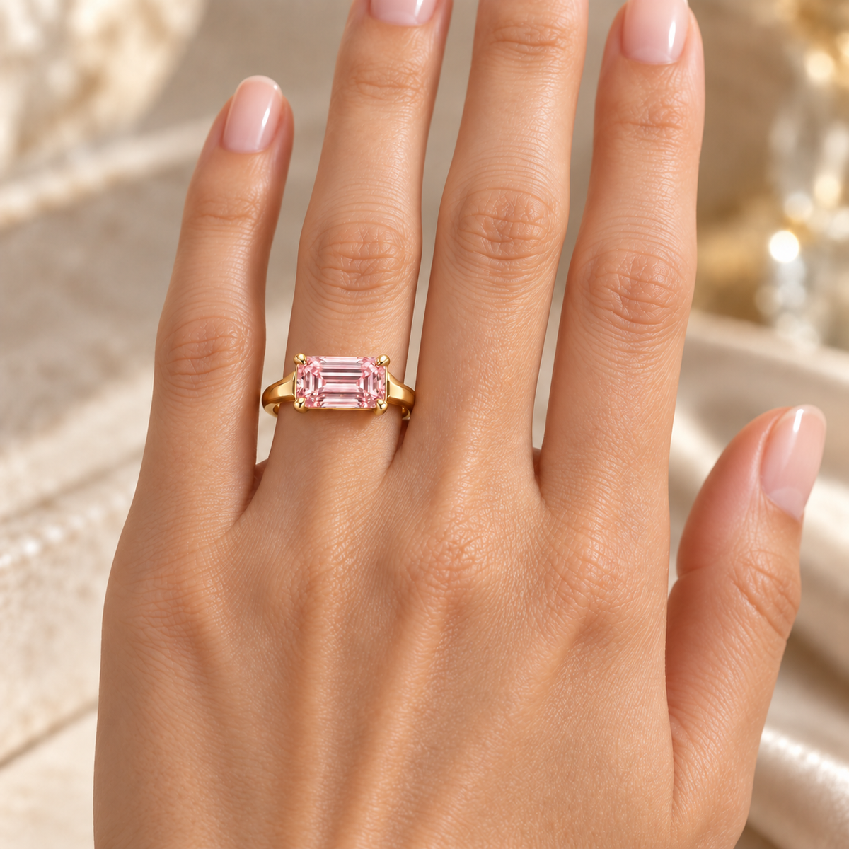 MISSISSI J02 pink emerald-cut ring worn on the ring finger of a left hand