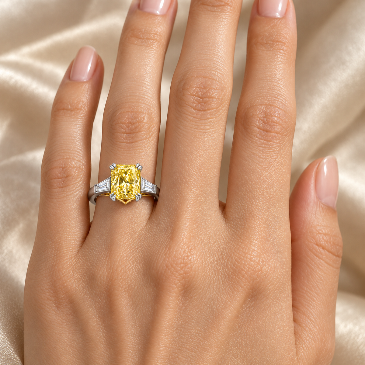 MISSISSI J03 yellow radiant three-stone ring worn on the ring finger of a left hand