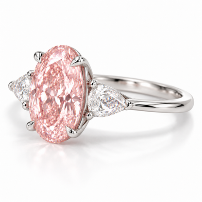 Opposite low oblique AI view of the oval pink-center ring showing the right pear-shaped side stone, four center claws and slim shank.