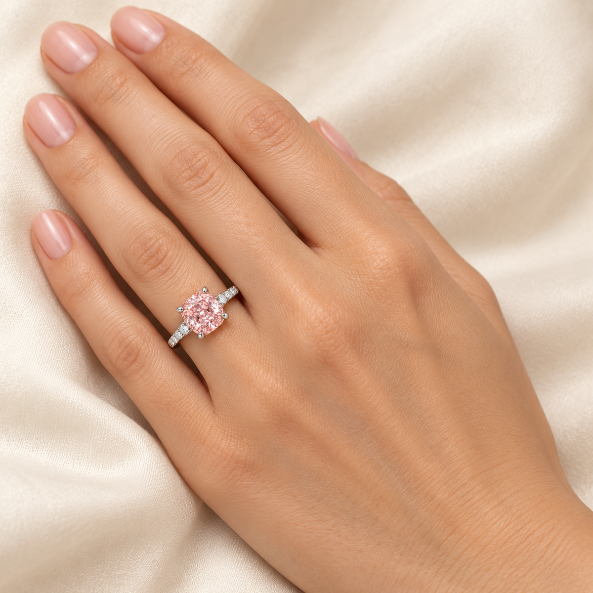 Rosecush pink cushion lab-grown diamond ring in white gold on a model's ring finger, AI-generated wearing visualization with illustrative scale