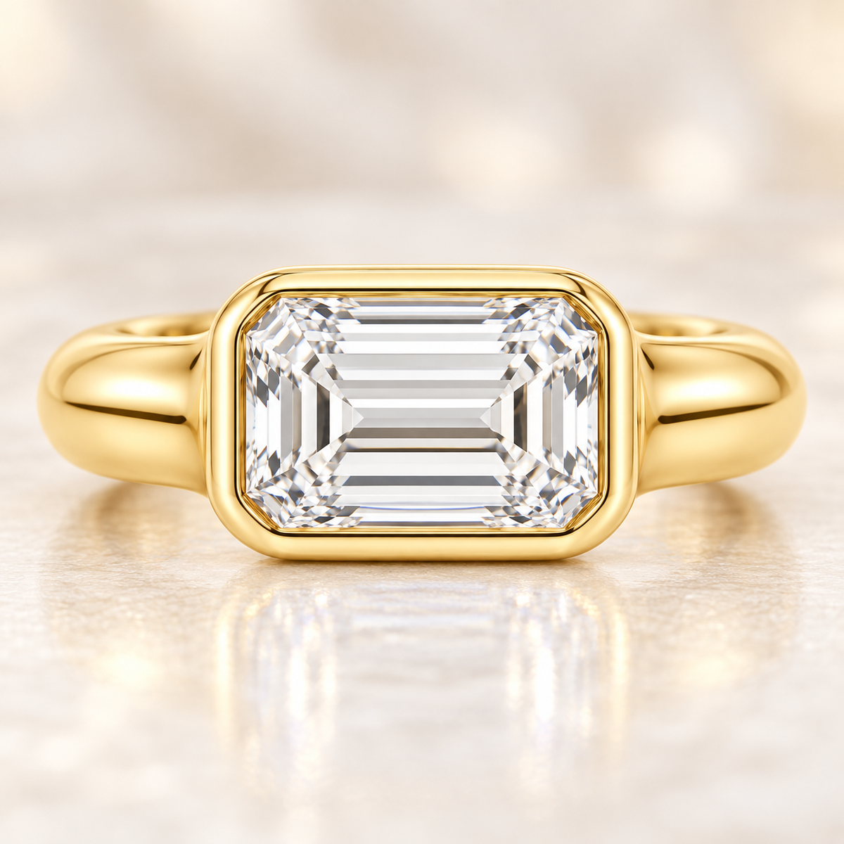 Serein east-west emerald-cut bezel engagement ring in 14K yellow gold, close-up of the diamond setting.