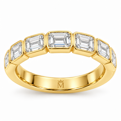 Solace east-west emerald-cut half-eternity wedding band in 14K yellow gold, interior crowned-M hallmark detail.