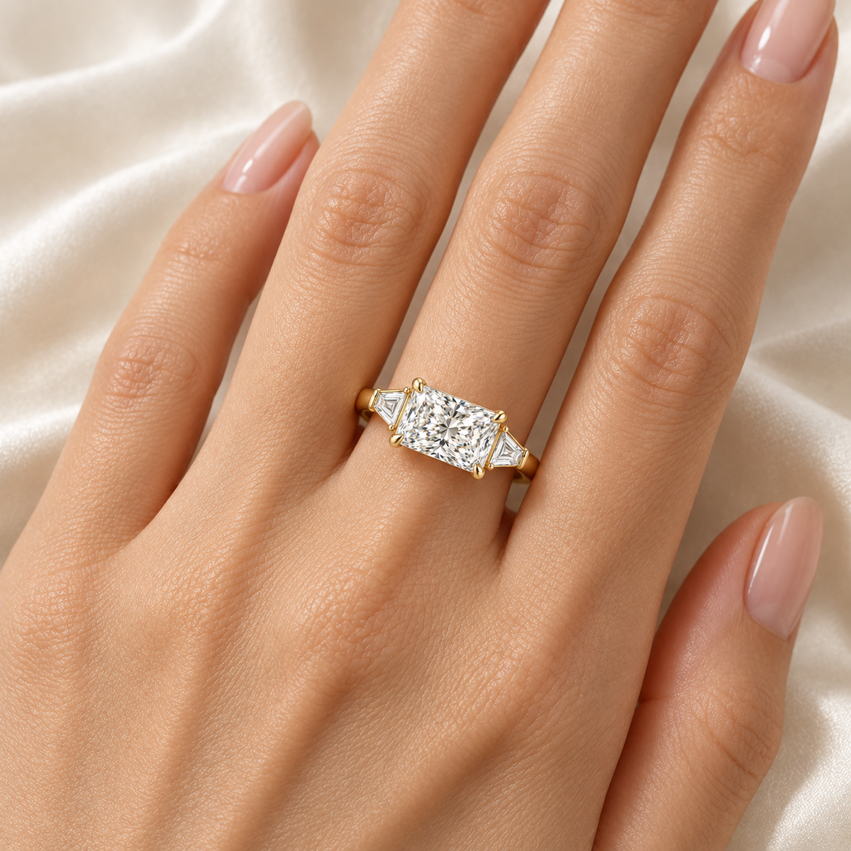 MISSISSI U03 east-west radiant lab-grown diamond three-stone ring in yellow gold, ring worn on an adult hand; design visualization