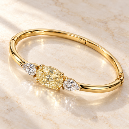 MISSISSI Yellow Oval Pear-Side Lab-Grown Diamond Bangle in yellow gold, angled product view on ivory stone; design visualization