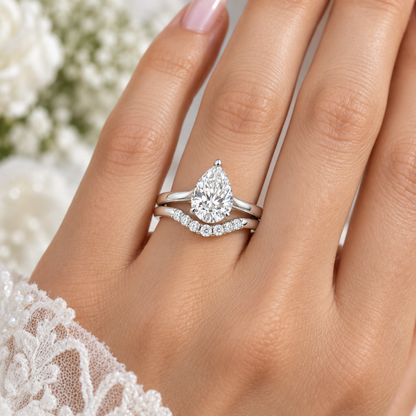Vow pear engagement ring and contoured wedding band set in 14K white gold, worn by a model.