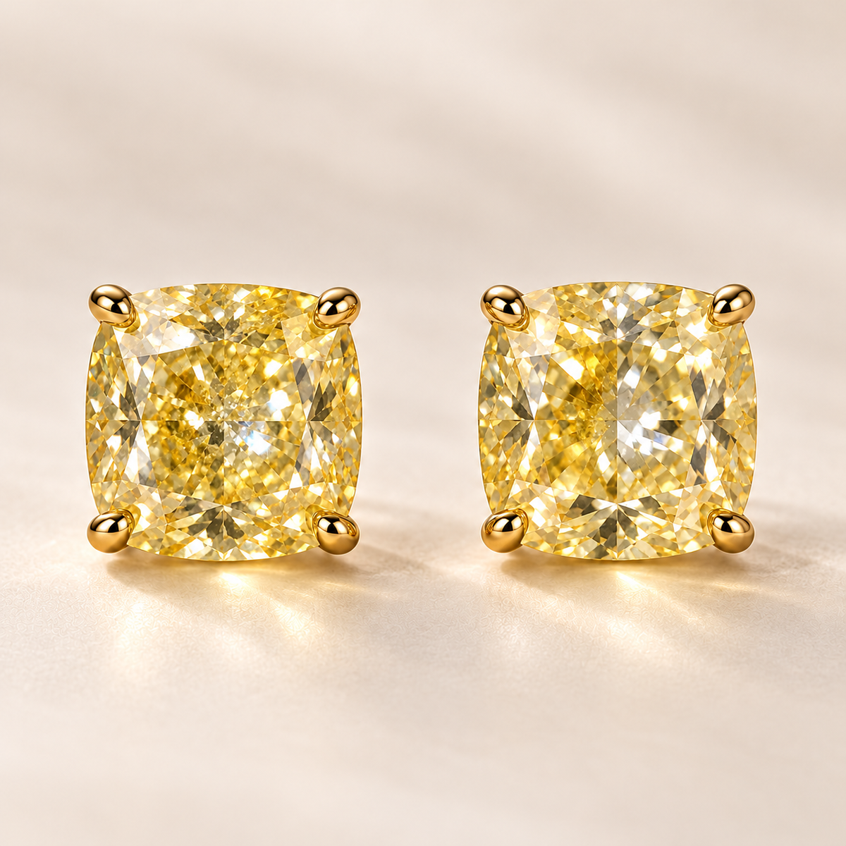 Design visualization of a pair of cushion-cut lab-grown yellow diamond stud earrings in four-prong settings