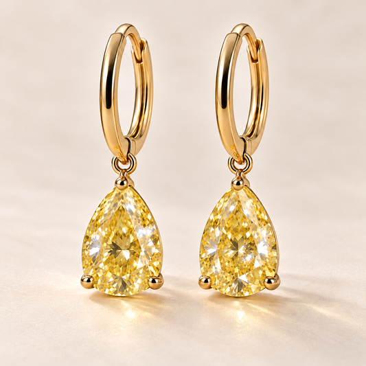 Design visualization of pear-shaped lab-grown yellow diamond drops suspended point-up below slim huggie-style hoops