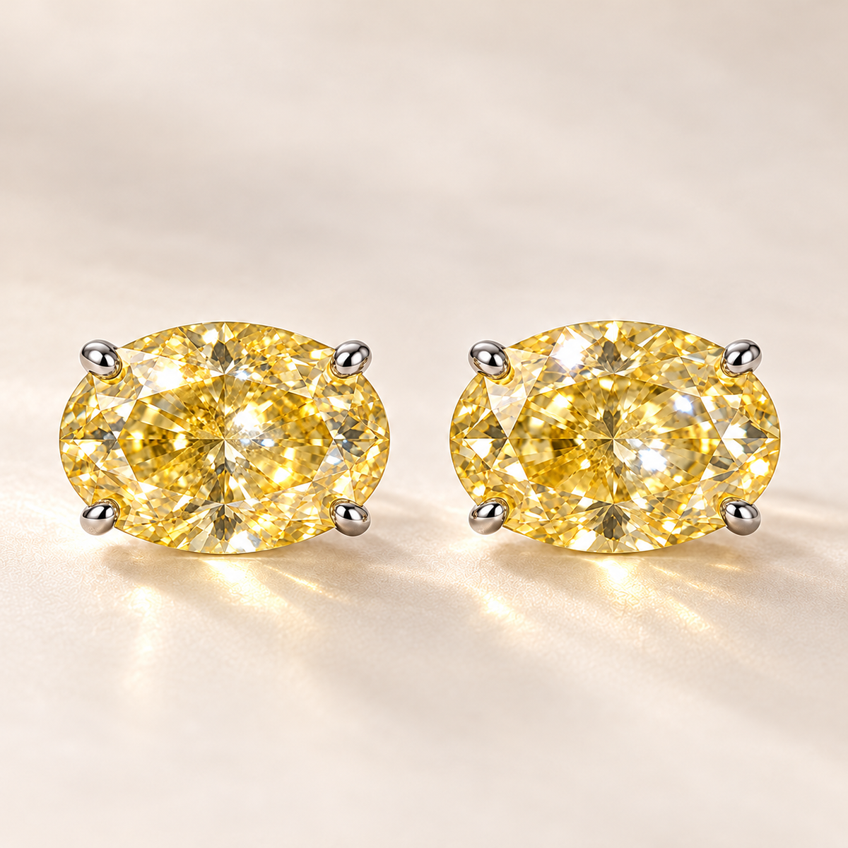 Design visualization of a pair of oval lab-grown yellow diamond stud earrings set horizontally in four-prong settings