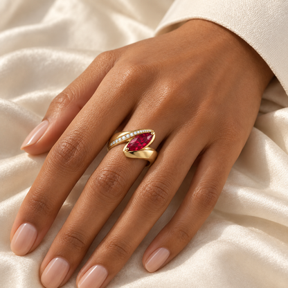MISSISSI RB25 RIBBON FOLD yellow gold marquise lab-grown ruby ring worn on a warm medium-brown skin model's hand; AI-generated design visualization.