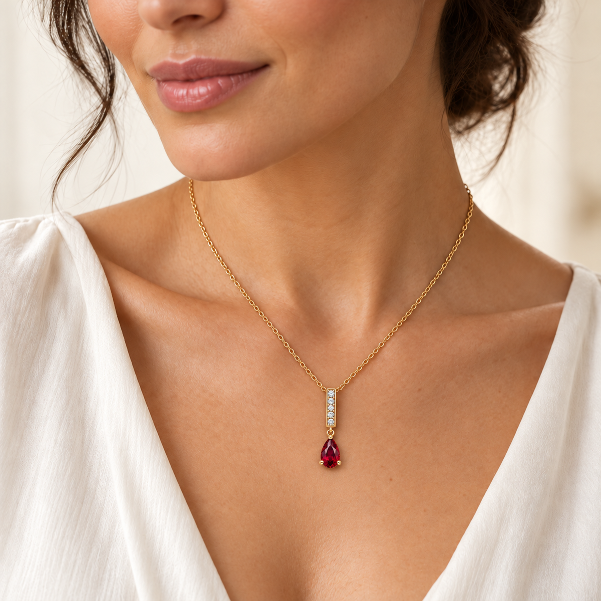 Design visualization of an adult model wearing the RB28 Ruby Line necklace in yellow gold, with a slim diamond baton and point-up pear lab-grown ruby.