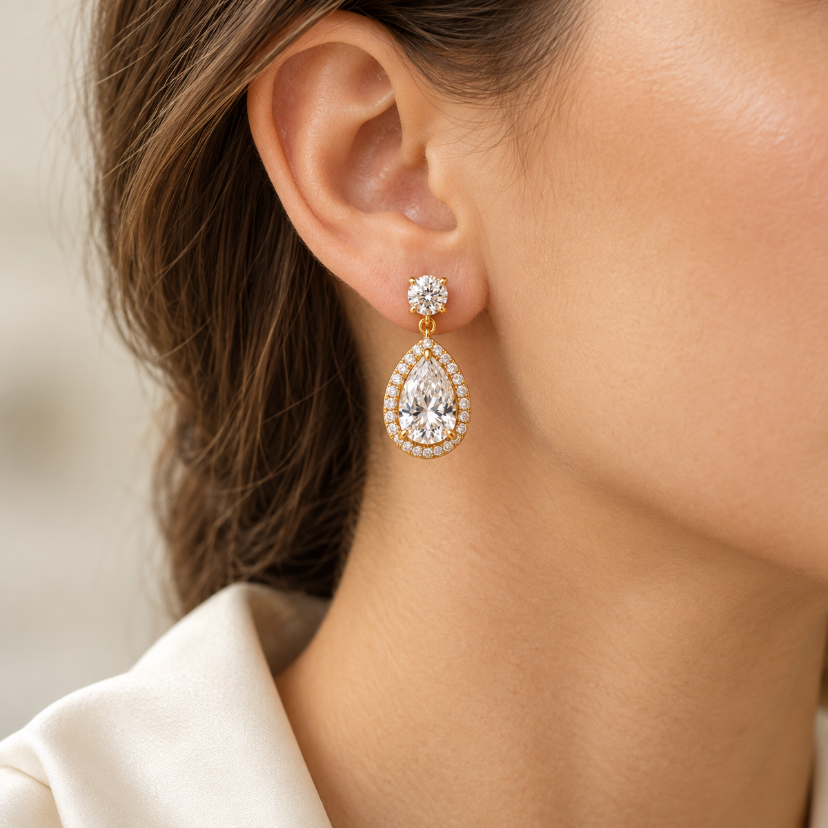 MISSISSI pear-halo lab-grown diamond drop earrings in yellow gold, one earring shown worn on an ear
