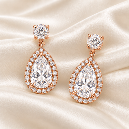 MISSISSI pear-halo lab-grown diamond drop earrings in rose gold, matching pair styled on ivory silk