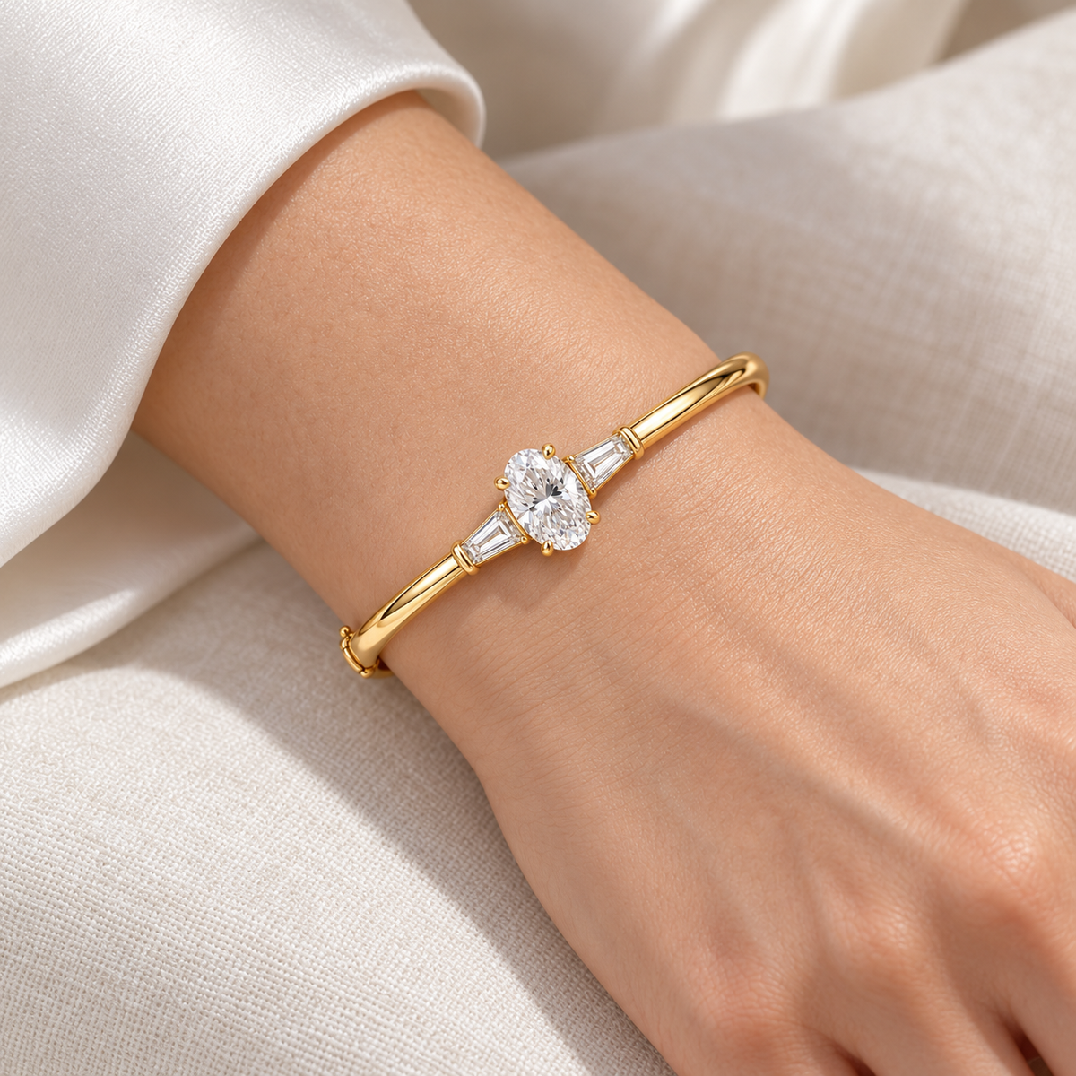 MISSISSI U09 Oval and Baguette bangle in 14K yellow gold, natural-scale adult wrist wear; design visualization of a closed oval bangle with a vertical oval diamond and two tapered baguette side diamonds.