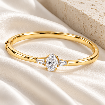 MISSISSI U09 Oval and Baguette bangle in 14K yellow gold, ivory silk and pale stone styling; design visualization of a closed oval bangle with a vertical oval diamond and two tapered baguette side diamonds.